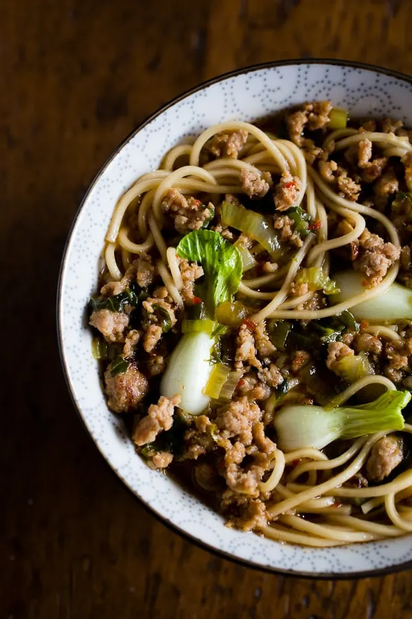 This spicy pork noodle bowl is packed full of flavor and ready in just 30 minutes. It's a quick and easy meal that is sure to please you whole family! Spicy ground pork sautéed with Sichuan peppercorns and swimming in a delicious broth with baby bok choy and perfectly cooked noodles.