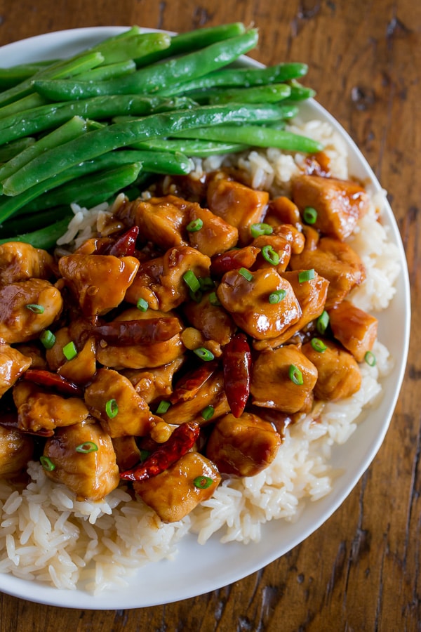 Healthier General Tso's Chicken on a plate with beans. 