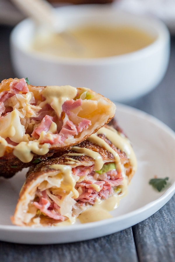 These reuben egg rolls are packed full of corned beef, cabbage, sauerkraut and Russian dressing. Fried till crispy and dipped in an beer mustard sauce. Easy to make and PACKED full of delicious reuben flavor.