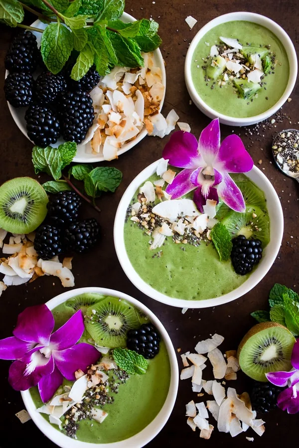This tropical green smoothie bowl is made with frozen bananas, mango, kiwi, mint, spinach, chia seeds, vanilla soy yogurt and coconut milk. It's ready in just 5 minutes and tastes like a tropical paradise. 