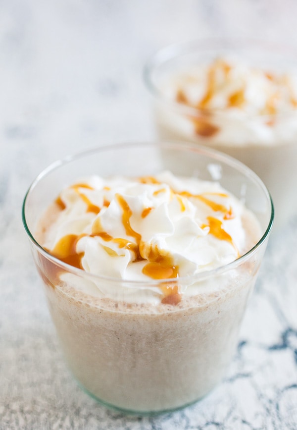boozy caramel apple butter milkshake in a small glass with whipped cream on top