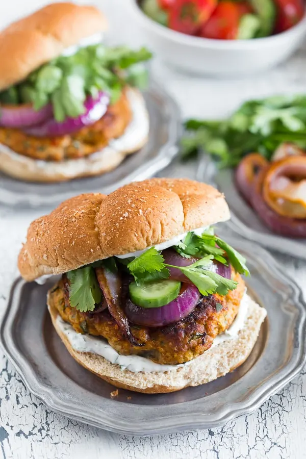 This chicken tandoori burger is packed full of spices and fresh chopped herbs. Piled high with fresh cilantro, cucumber, grilled onions and Greek yogurt sauce. This burger is perfect for all your summer BBQ parties!