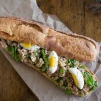 This pesto tuna baguette sandwich is the perfect summer sandwich. Fresh basil pesto mixed with olive oil canned yellowfin tuna and piled high on a baguette with arugula and hard boiled eggs. You'll love this sandwich!