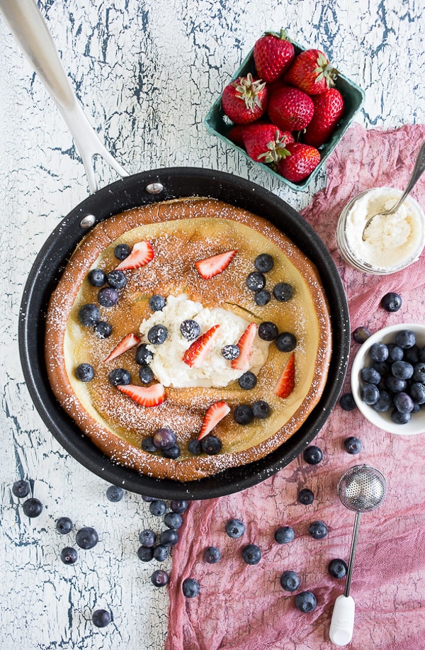 Vanilla Bean Dutch Baby in a skillet with whipped mascarpone. 