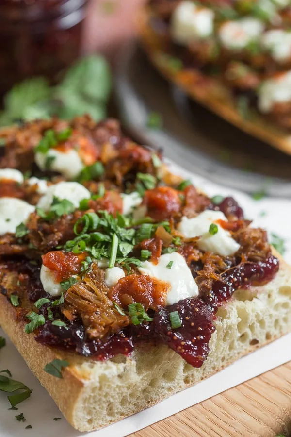 This fig and pig open-faced sandwich is the perfect way to bring flavor to your lunch or dinner. Crusty garlic bread topped with vanilla fig preserves, pulled pork, queso blanco cheese, chipotle salsa, cilantro and green onions.