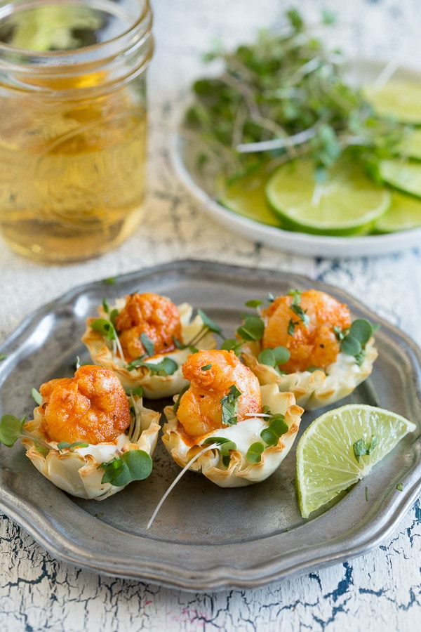 Tequila Lime Shrimp Phyllo Cups on a plate with a beer in the background. 