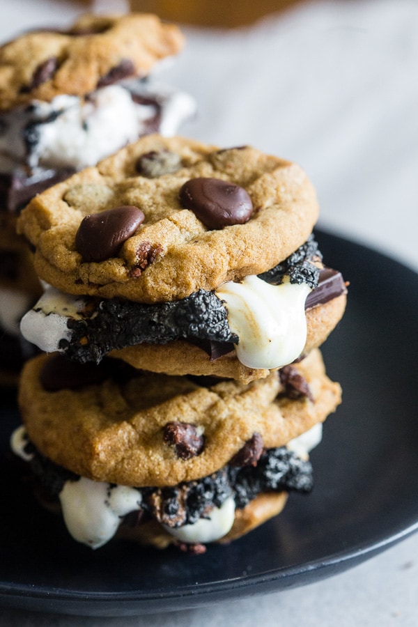 These peanut butter chocolate chip cookie s'mores take all the flavor of a childhood favorite and kick it up a few notches! What's not to love about toasted marshmallows and dark chocolate sandwiched in between peanut butter chocolate chip cookies?
