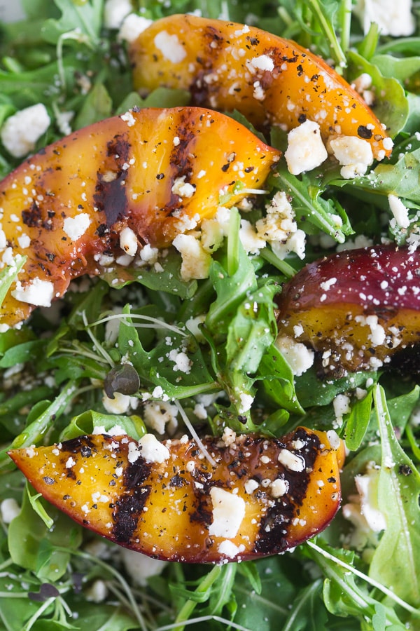 A grilled nectarine on a salad. 