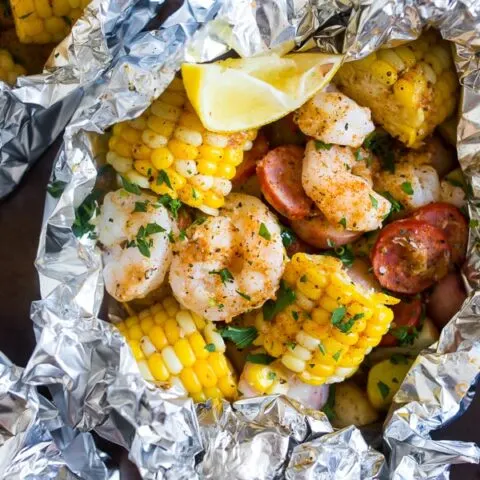 low country boil foil packets on a sheet pan wrapped in foil