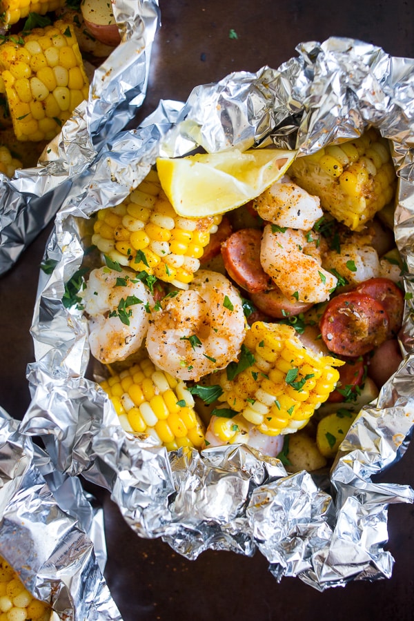 low country boil foil packets on a sheet pan wrapped in foil