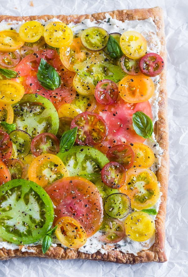This super simple heirloom tomato tart is made with puff pastry, lemon and fresh herb ricotta and covered with lots of freshly sliced heirloom tomatoes. Ready in just 25 minutes and perfect for an appetizer or a light dinner.