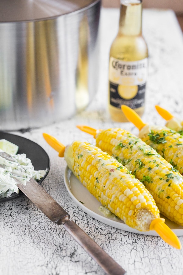 Beer Steamed Corn on the Cob on a plate with corn holders. 