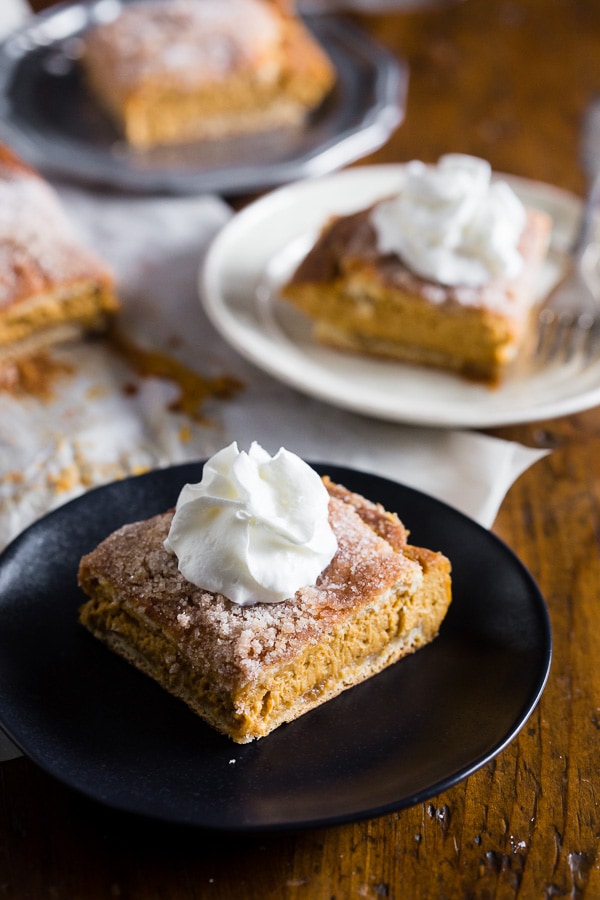 These pumpkin churro cheesecake bars are going to be your new favorite fall treat! A fun twist to pumpkin cheesecake with a crispy pumpkin spice sugar crescent roll topping. Super easy to make and perfect for all your holiday dessert tables! 