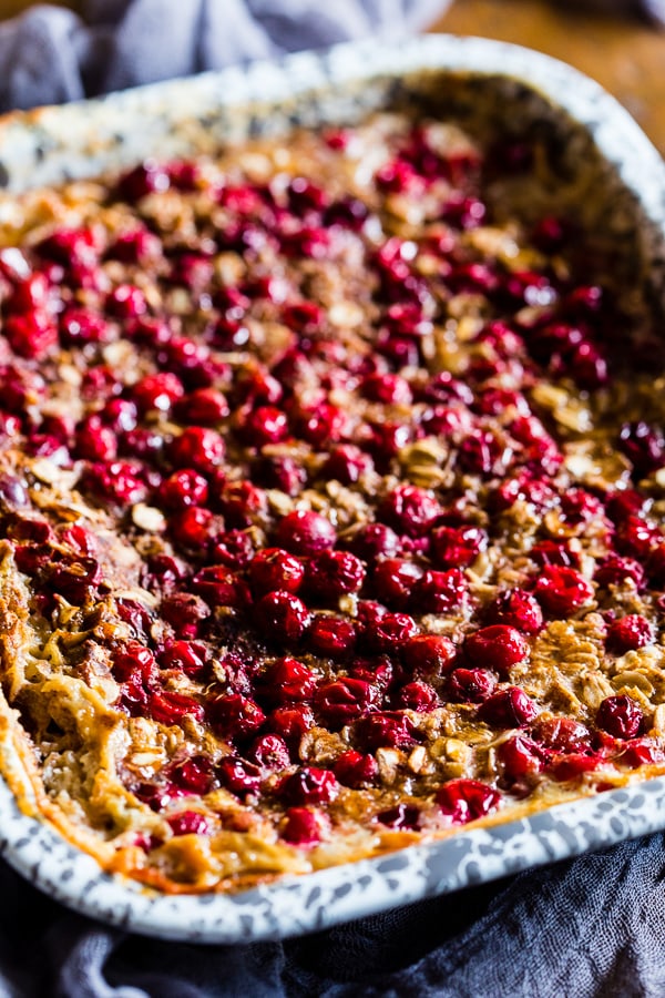 Baked Cranberry Oatmeal in a dish drizzled with maple syrup. 