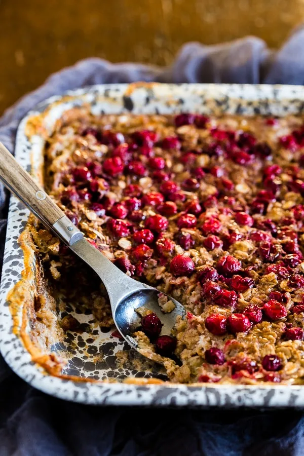 This baked cranberry oatmeal is ready in under an hour and reheats perfectly for a hearty breakfast all week long. Plus it's a great use for all those fall cranberries and delicious maple syrup.