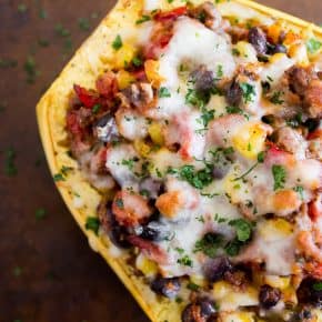 southwest taco stuffed spaghetti squash topped with cheese on a sheetpan