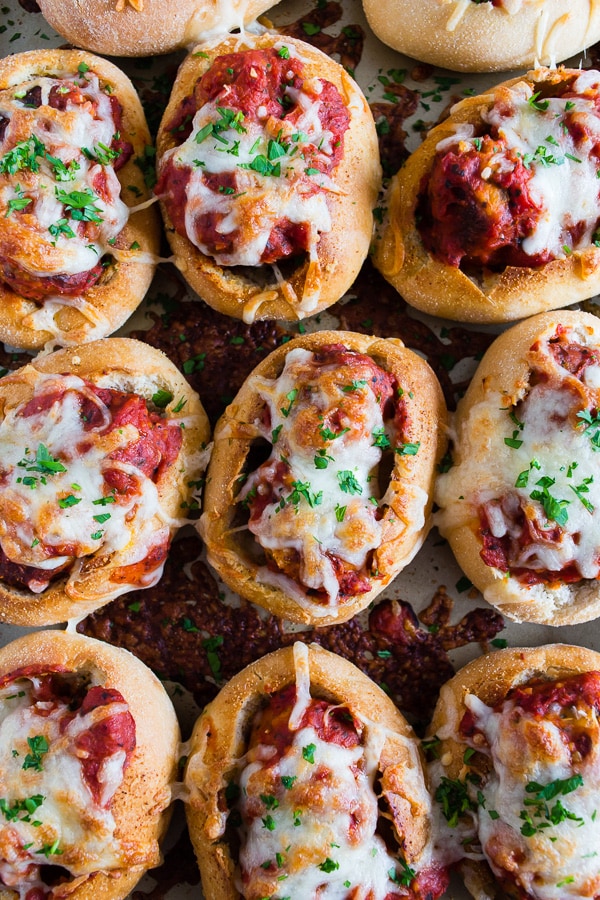 Mini Chicken Parmesan Meatball Subs lined up on a sheet pan. 