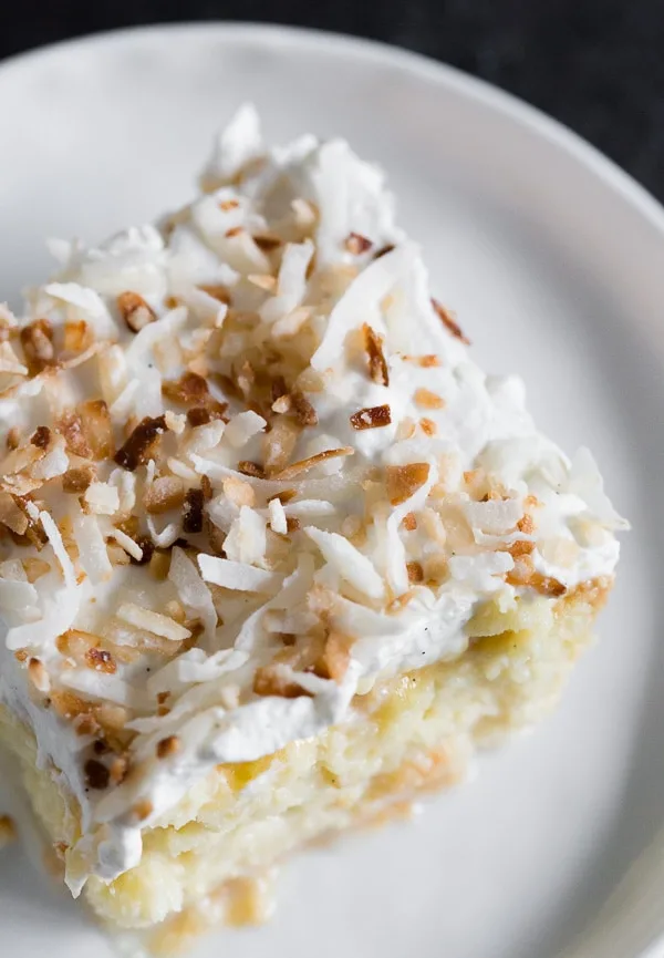 Toasted Coconut Tres Leches Cake sliced on a plate. 