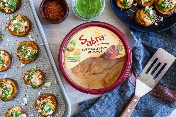 These pesto hummus sweet potato bites are the perfect bite size appetizer. Sumac roasted sweet potato rounds topped with spicy hummus, drizzled with spinach pesto and sprinkled with crumbled feta - how delicious is that! 