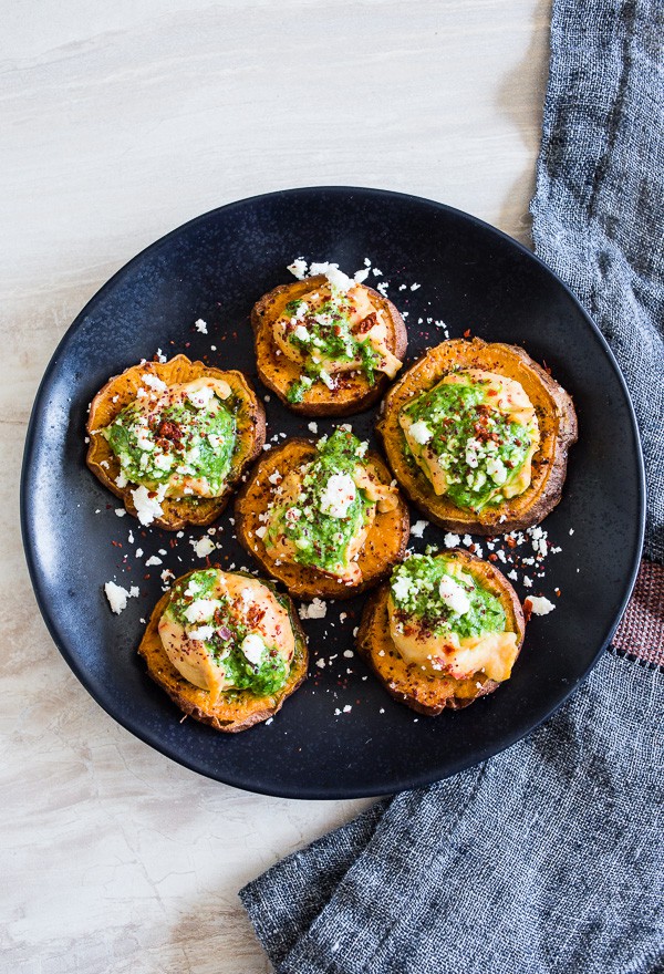 These pesto hummus sweet potato bites are the perfect bite size appetizer. Sumac roasted sweet potato rounds topped with spicy hummus, drizzled with spinach pesto and sprinkled with crumbled feta - how delicious is that!