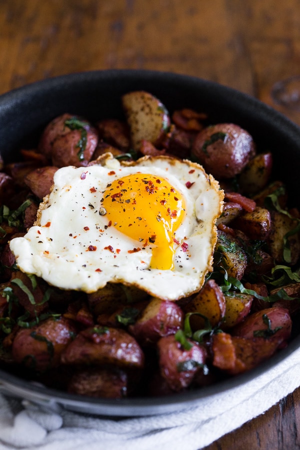 Basil Bacon Hash topped with a fried egg that has a runny yolk. 