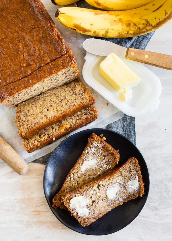 Coconut Rum Lime Glazed Banana Bread spread with butter. 