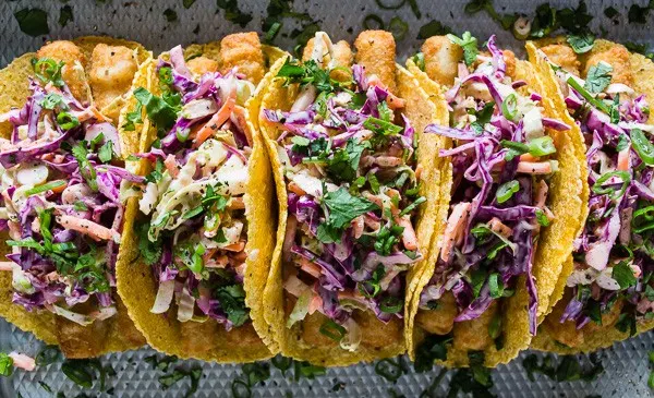 These easy fish tacos with citrus Greek yogurt slaw are the perfect busy weeknight meal. Super crispy fish topped with a crazy easy cabbage slaw made with Greek yogurt and lime juice. You'll love how easy these tacos come together!