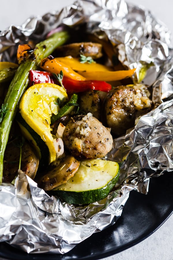 This chicken sausage and vegetable foil packet dinner is super simple to make and perfect for summer. Packed full of chicken sausage, sweet peppers, zucchini, yellow squash, red onion, green beans and drizzled with a herbed olive oil. You'll love this simple dinnertime recipe!