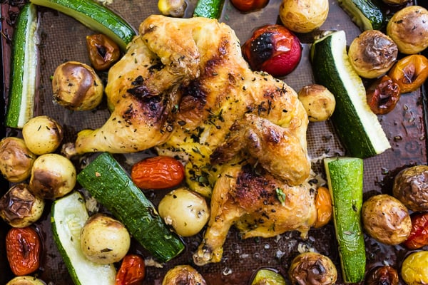 This sheet pan spatchcocked Cornish hens with summer vegetables is the perfect weeknight dinner. It all bakes up on one sheet pan and is packed with perfectly crisp Cornish hens, zucchini, baby potatoes and cherry tomatoes all tossed in an olive oil, oregano, thyme mixture. You'll love this sheet pan meal!
