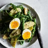 This tangy green bean and potato salad is the perfect combination of buttery fingerling potatoes, crunchy blanched green beans, peppery arugula and soft boiled eggs all tossed in a creamy Dijon and caper vinaigrette. It's tangy, perfect for hot summer nights and makes an amazingly fast and easy meatless dinner!
