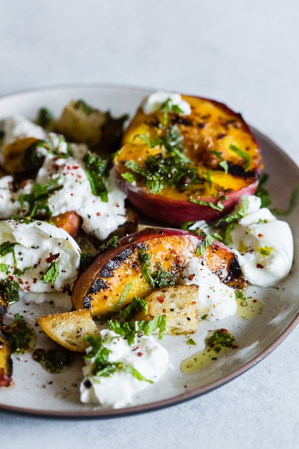 a plate with grilled peach burrata salad on it