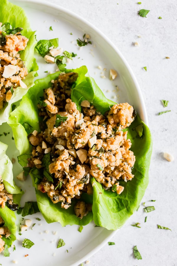 These Thai ground chicken lettuce cups are a super simple dinner that is packed full of flavor and perfect for a light summer meal. Ground chicken mixed with ginger, lemongrass, fish sauce, soy sauce and sprinkled with chopped peanuts and lots of cilantro. You'll love these lettuce cups!