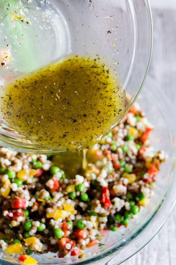 This lentil couscous goat cheese salad is PACKED full of flavor and the perfect meatless meal, light summer lunch or delicious side dish. Green lentils mixed with Israeli couscous, goat cheese, bell peppers, green peas, sun dried tomatoes, and parsley all drizzled with a homemade lemon, basil, and honey vinaigrette.