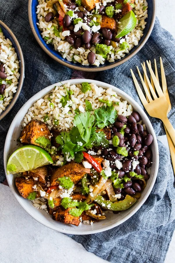 These sweet potato black bean burrito bowls are the perfect vegetarian meal to add to your weekly meal plan. Delicious cilantro lime rice piled high with black beans, roasted sweet potatoes, and vegetables. Trust me, you’ll go crazy over this bowl!