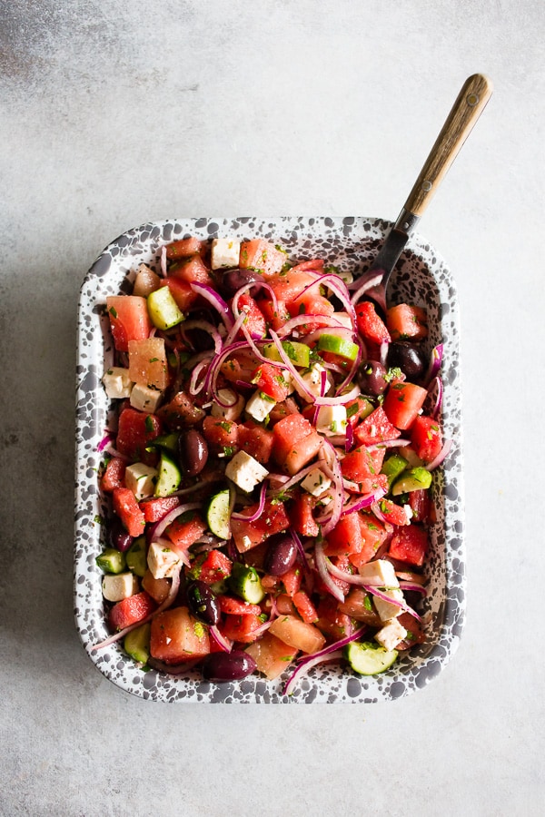 This watermelon Greek salad is a refreshing take on the classic Greek salad. Full of sweet watermelon, red onions, cucumbers, olives, feta cheese and lots of fresh herbs. You'll love this simple summer salad! 