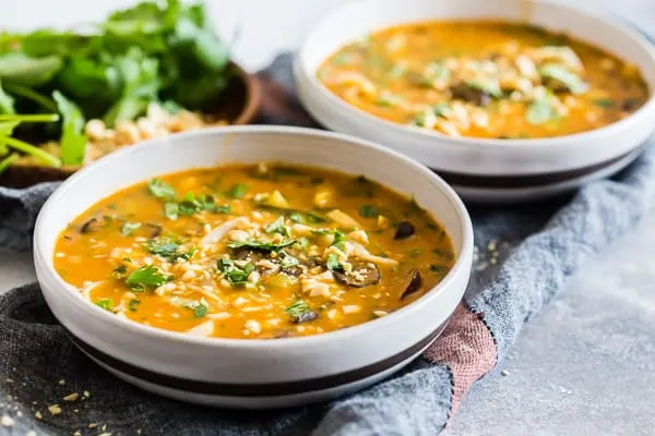 Vegan Red Curry Pumpkin Noodle Soup in 2 ceramic bowls. 