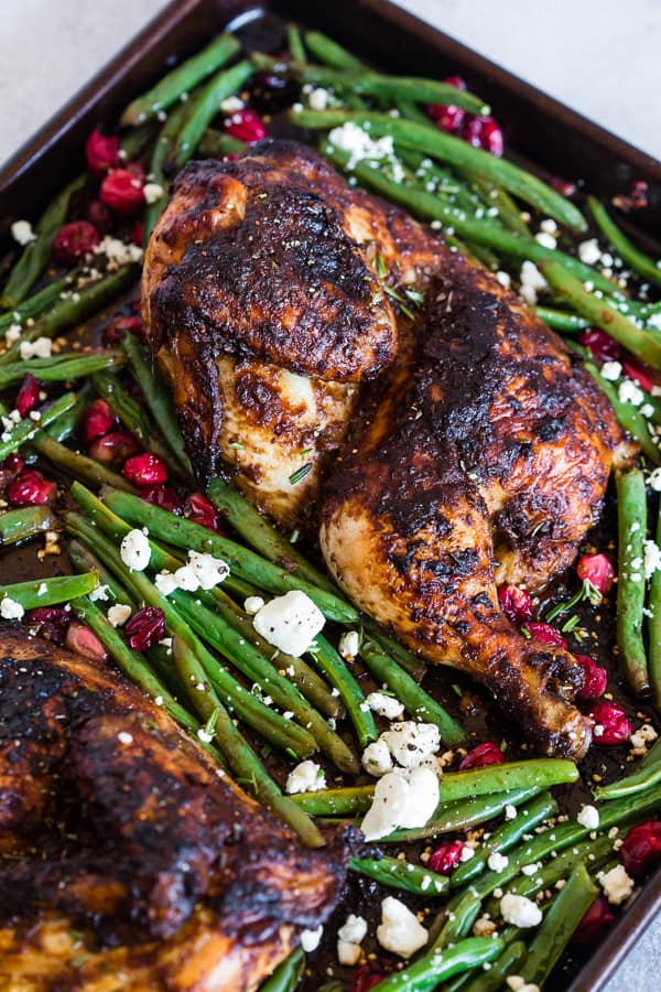 This sheet pan cranberry balsamic chicken and green beans is the perfect holiday meal for two. Chicken halves marinated in a cranberry balsamic sauce and served with roasted green beans, fresh cranberries, and goat cheese. 