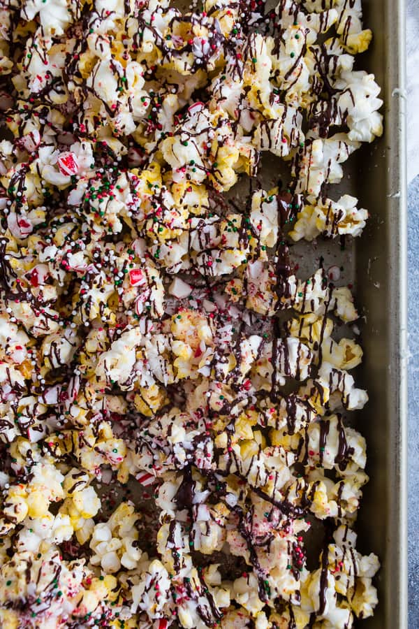 This peppermint bark popcorn is the EASIEST Christmas candy snack ever! Lightly buttered popcorn topped with white chocolate, dark chocolate, crushed candy canes, and sprinkles. You'll love this flavor packed snack!