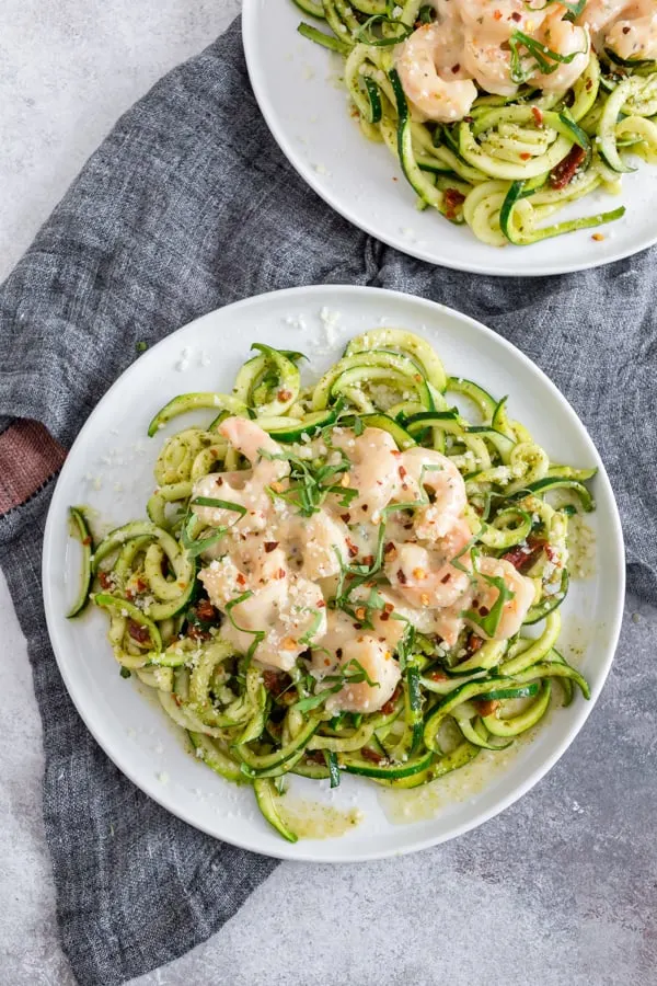 These garlic shrimp pesto zoodles are the perfect quick and easy weeknight meal. Spiralized zucchini tossed in pesto and topped with creamy garlic butter shrimp. You're going to love this recipe! 