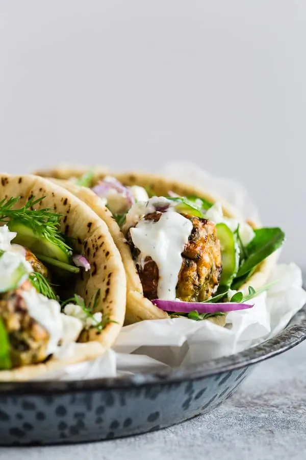 Greek Chicken Meatball Gyros topped with tzatziki. 