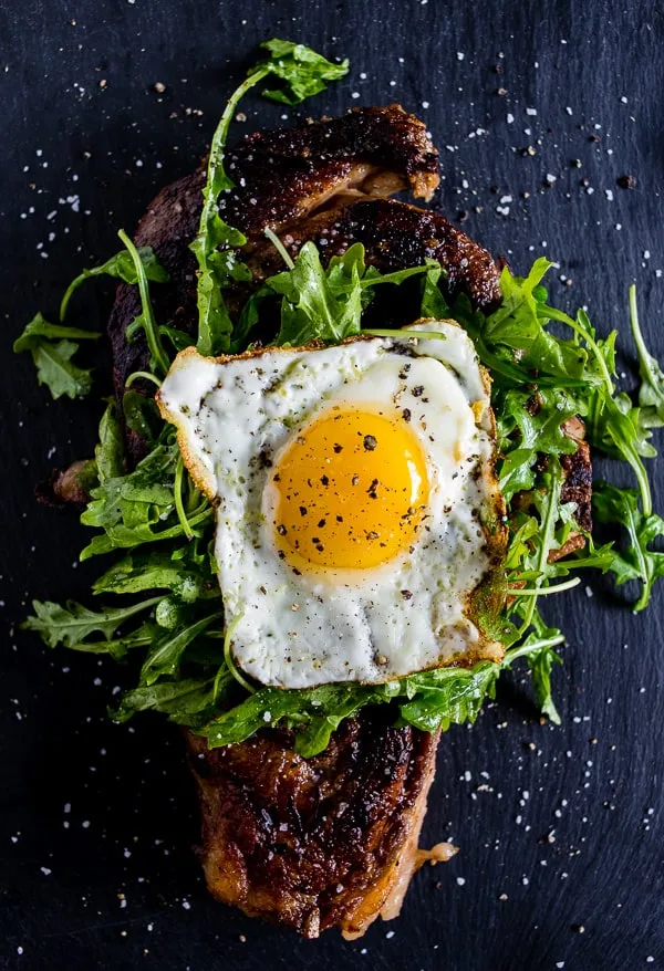 This fried egg topped steak is your breakfast or dinner of your dreams. Deliciously seasoned steak grilled and then topped with a lightly dressed arugula salad and a super crispy around the edges fried egg. This is the type of dish you'll devour and dream about! 