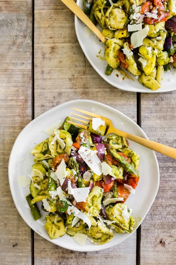 This roasted vegetables tortellini salad is the perfect way to use up all those summer vegetables. Perfectly roasted vegetables mixed with cheese tortellini and tangy basil vinaigrette mixed together and sprinkled with shaved Parmesan cheese. You'll love this easy salad! 