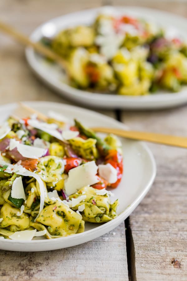 This roasted vegetable tortellini salad is the perfect way to use up all those summer vegetables. Perfectly roasted vegetables mixed with cheese tortellini and tangy basil vinaigrette mixed together and sprinkled with shaved Parmesan cheese. You'll love this easy salad! 
