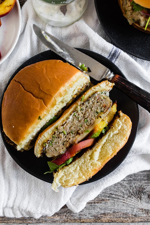 Cheesy Grilled Peach Jalapeno Turkey Burger cut in half on a plate. 