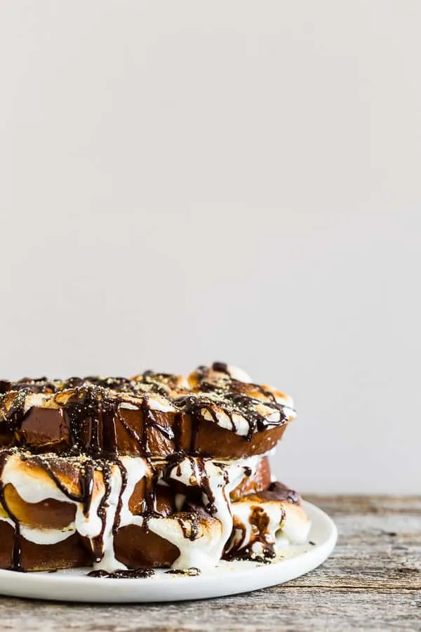 This s'mores French toast is LOADED with bigtime marshmallow flavor and the perfect special occasion sweet breakfast or over-the-top dessert. Thick sliced vanilla bean challah bread French toast topped with toasted marshmallows, drizzled with chocolate sauce and sprinkled with graham cracker crumbs.