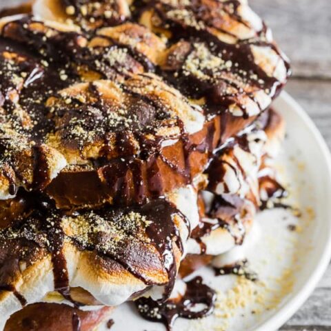 This s'mores French toast is LOADED with bigtime marshmallow flavor and is the perfect special occasion sweet breakfast or over-the-top dessert. Thick sliced vanilla bean challah bread French toast topped with toasted marshmallows, drizzled with chocolate sauce and sprinkled with graham cracker crumbs. What's not to love?