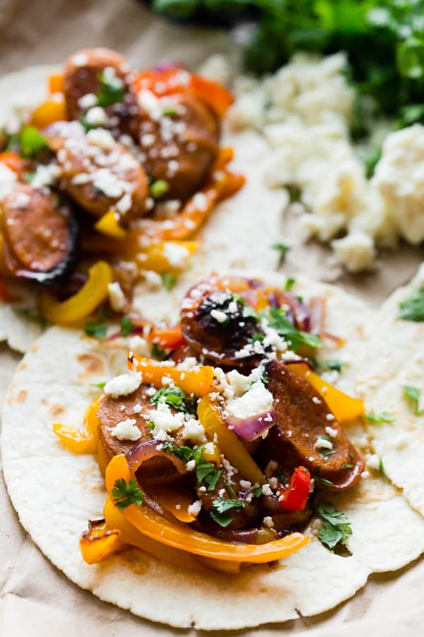 These sheet pan chicken sausage fajitas are a great weeknight meal that can feed a hungry crowd. Sweet peppers, red onions, and juicy chicken sausage all tossed together with a homemade fajita seasoning and topped with fresh chopped cilantro and crumbly cotija cheese.