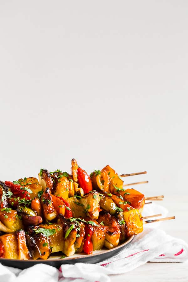 Pineapple Chicken Kebabs on a black plate. 