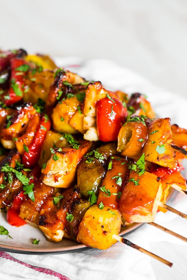 Pineapple Chicken Kebabs sitting on a serving plate. 