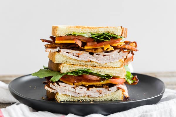 This turkey and cheese BLT sandwich is the perfect back to school sandwich. It combines lightly toasted bread with a homemade garlic basil mayonnaise, sliced turkey, sharp cheddar cheese, crispy bacon, sliced tomato and baby arugula. It's flavorful, easy to make and a step above your everyday bagged lunch sandwich.